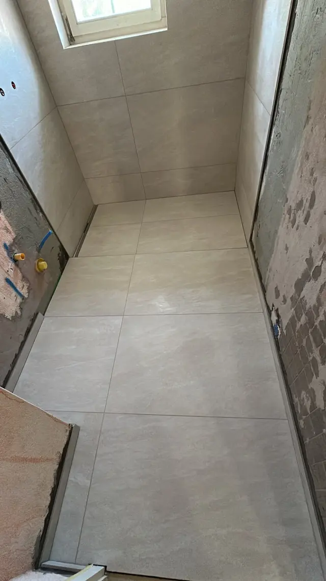 Bad im Altbau: Grossformat an Boden und Wand unter der Dachschräge