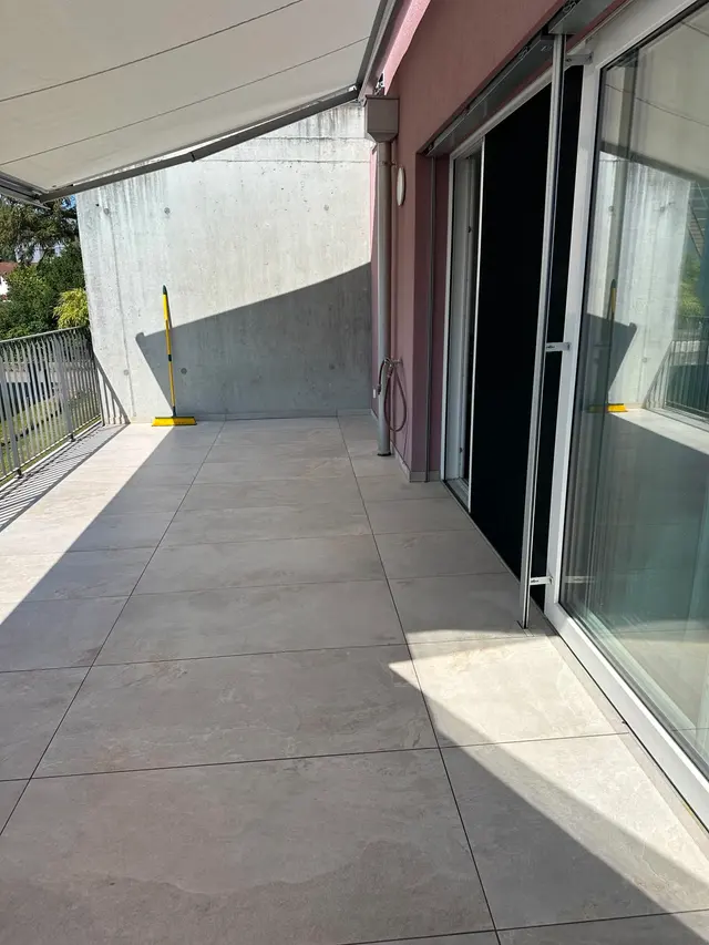 Balkon, Terrassenplatten: Grossformatige Aussenplatten in Steinoptik, sauber an Fassade und Türschwelle angeschlossen