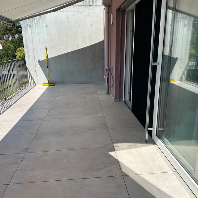 Balkon, Terrassenplatten: Grossformatige Aussenplatten in Steinoptik, sauber an Fassade und Türschwelle angeschlossen