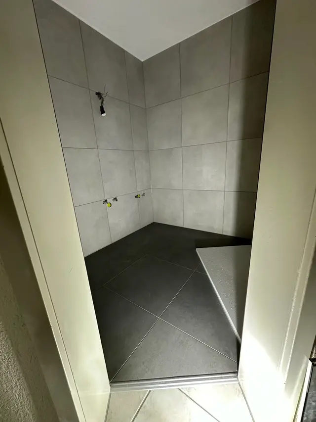 Bodenebene Dusche, Gefälle: Diagonal geschnittene Bodenplatten für das Gefälle zum Punktablauf