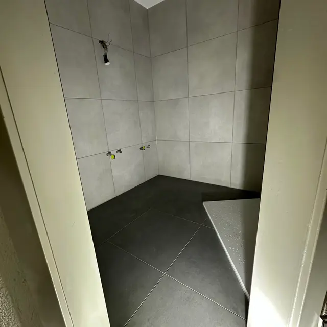 Bodenebene Dusche, Gefälle: Diagonal geschnittene Bodenplatten für das Gefälle zum Punktablauf