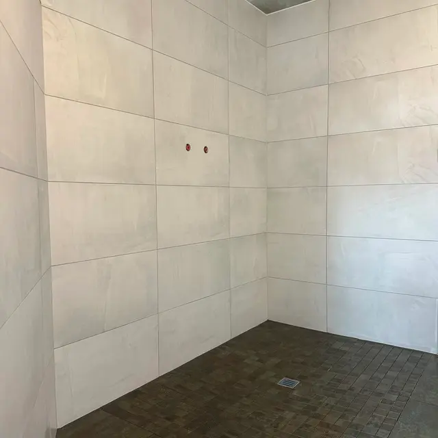 Bodenebene Dusche, Mosaik: Duschboden aus Mosaik mit Gefälle zum Ablauf, Wände in hellem Grossformat