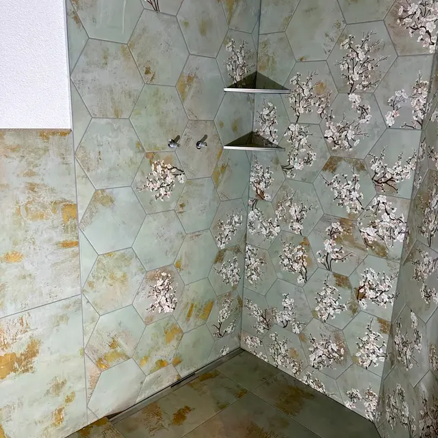 Dusche mit Hexagon-Dekor: Sechseckige Dekorplatten mit Blütenmotiv, Eckablage aus dem gleichen Material