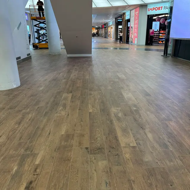 Grossflächige Verlegung von Feinsteinzeug in Holzoptik in einem Einkaufszentrum, ausgeführt von Bahoz Baukeramik