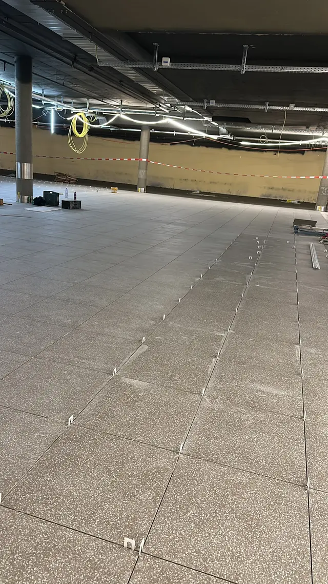 Grossfläche im Untergeschoss: Feinsteinzeug in Granitoptik, Reihe für Reihe mit Nivelliersystem verlegt