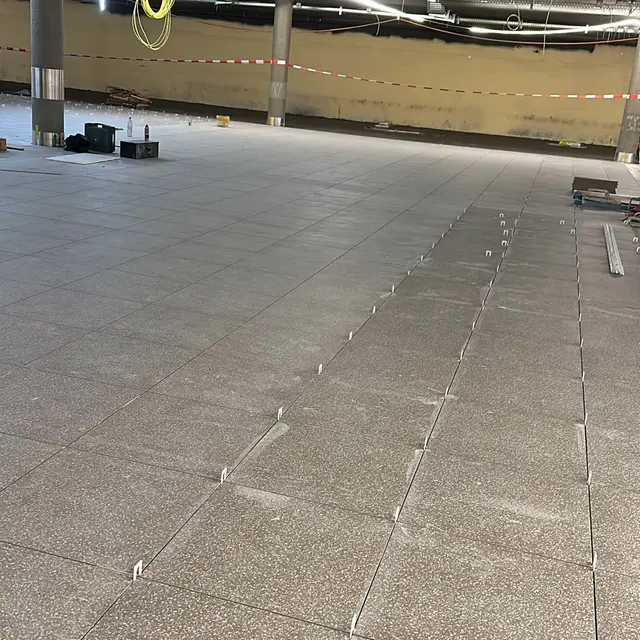 Grossfläche im Untergeschoss: Feinsteinzeug in Granitoptik, Reihe für Reihe mit Nivelliersystem verlegt