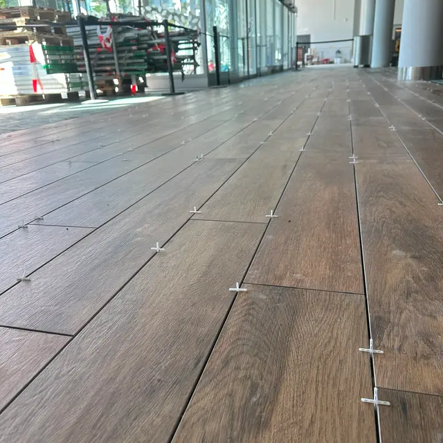 Gewerbefläche, Verlegung: Holzoptik-Planken mit sichtbarem Nivelliersystem gesetzt