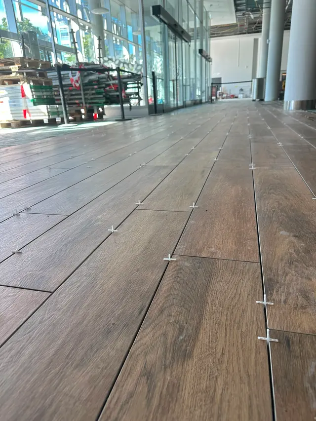 Gewerbefläche, Verlegung: Holzoptik-Planken mit Nivelliersystem gesetzt, damit die Fläche ohne Überzähne bleibt