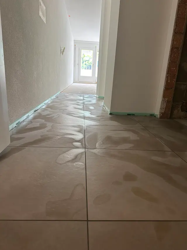 Korridor, Grossformat: Helle Bodenplatten in Steinoptik durch den Wohnungsflur, durchgehendes Fugenraster