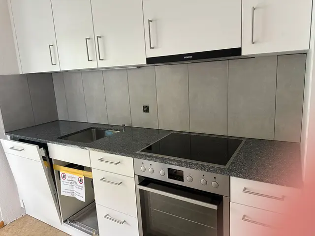 Küchenrückwand: Grossformatplatten in Betonoptik zwischen Abdeckung und Oberschränken