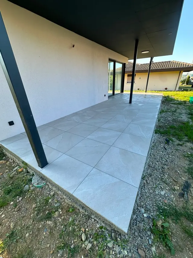 Gedeckter Sitzplatz: Terrassenplatten in Steinoptik, frostsicher verlegt mit sauberem Randabschluss
