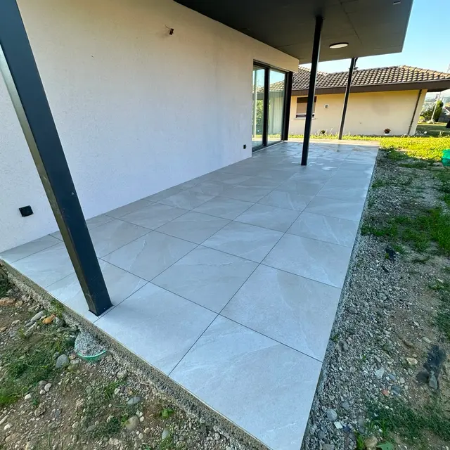 Gedeckter Sitzplatz: Terrassenplatten in Steinoptik unter einem gedeckten Sitzplatz