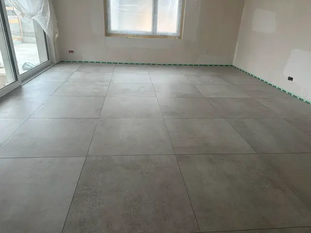 Wohnraum, Grossformat: Bodenplatten in Betonoptik, ruhiges Fugenbild über die ganze Fläche