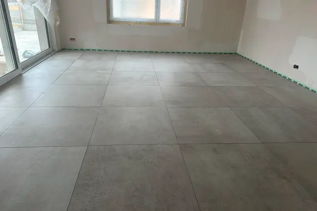 Wohnraum, Grossformat: Bodenplatten in Betonoptik, ruhiges Fugenbild über die ganze Fläche